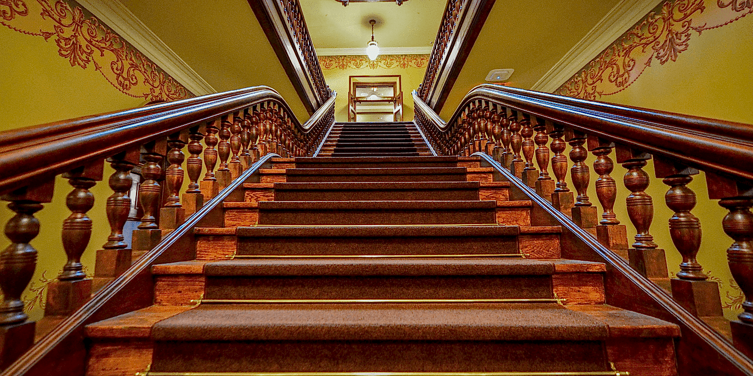 Barbers Flooring | an image displaying a stair runner in a gran entranceway